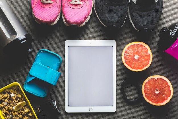 Früchte und Sportausrüstung in der Nähe von Tablet