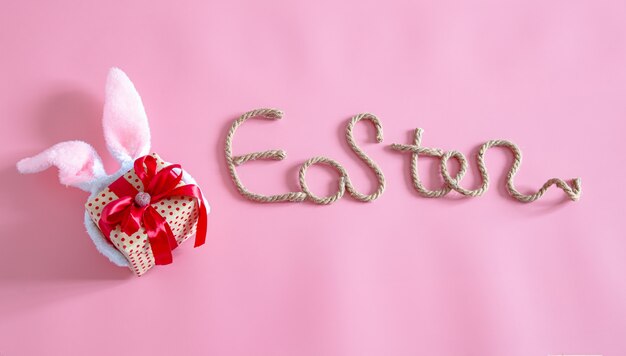 Frühling Ostern festlich. Oster kreative Inschrift auf Rosa mit Gegenständen des Osterdekors.