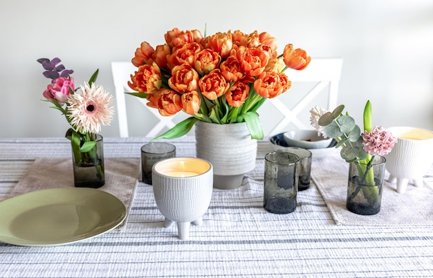 Frühlingsblumen und Kerzen auf dem Tisch im Inneren des Zimmers