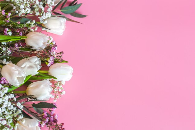 Frühlingsblumenanordnung auf einem rosa Hintergrund