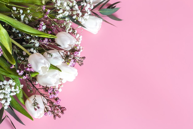 Frühlingsblumenanordnung auf einer rosa Wand