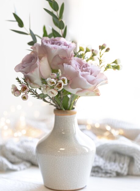 Frühlingskomposition mit einem Blumenstrauß in einer Vase in der Nähe