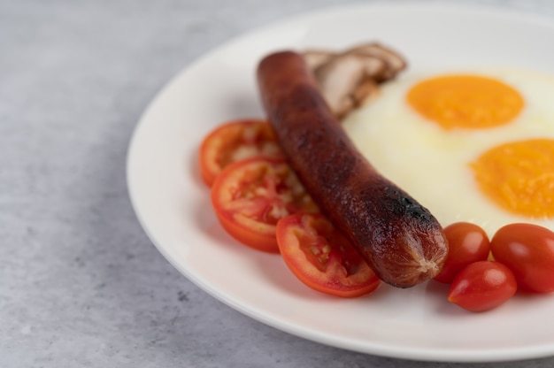 Frühstück bestehend aus Brot, Spiegeleiern, Tomaten, chinesischer Wurst und Pilzen.