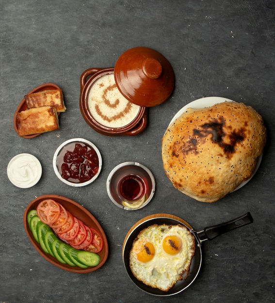 Frühstück mit Spiegeleiern, Brei, Pfannkuchen und Marmelade