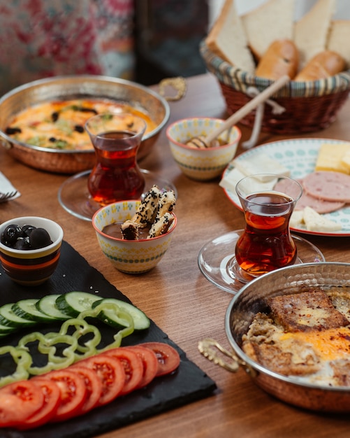 Frühstück mit verschiedenen Speisen und schwarzem Tee