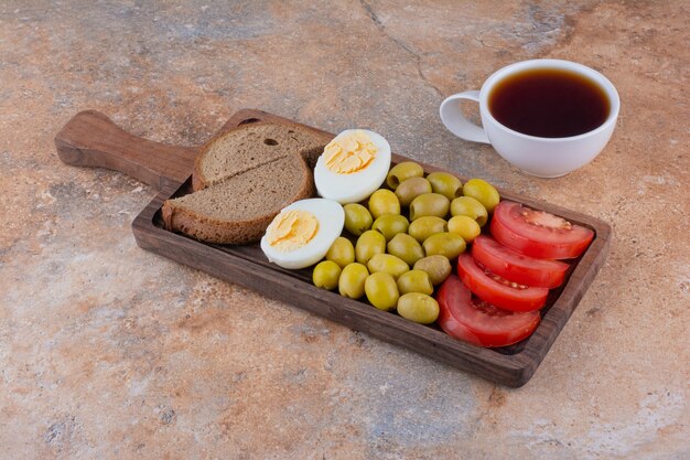 Frühstücksplatte mit Brot und einer Tasse Tee