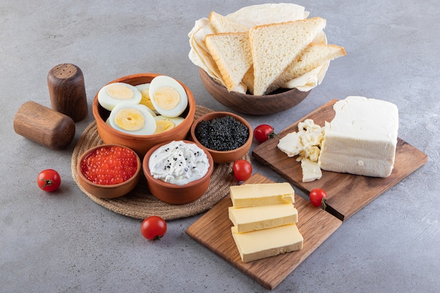 Frühstückstisch mit Eiern, Brot, Butter und Kaviar.