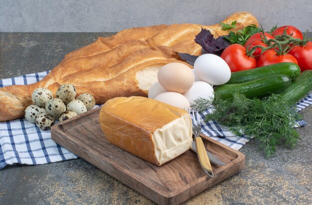 Frühstückstisch mit Gemüse, Brot, Eiern und Käse.