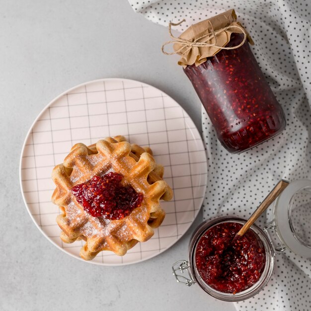 Frühstückswaffeln und Himbeermarmelade liegen flach