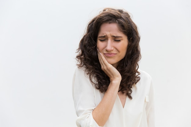 Frustrierte unglückliche Frau, die unter Zahnschmerzen leidet