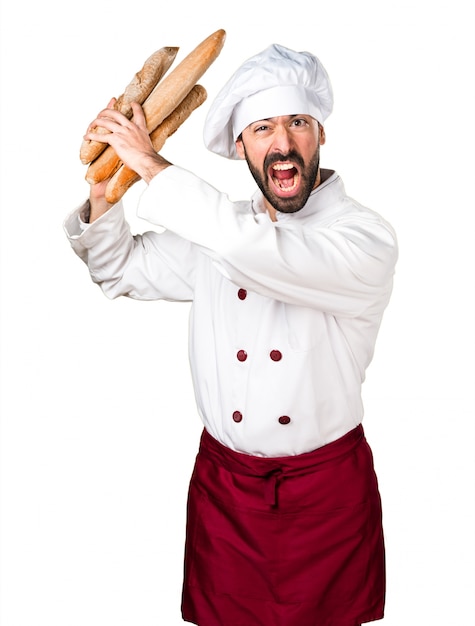 Frustrierter junger Bäcker, der etwas Brot hält