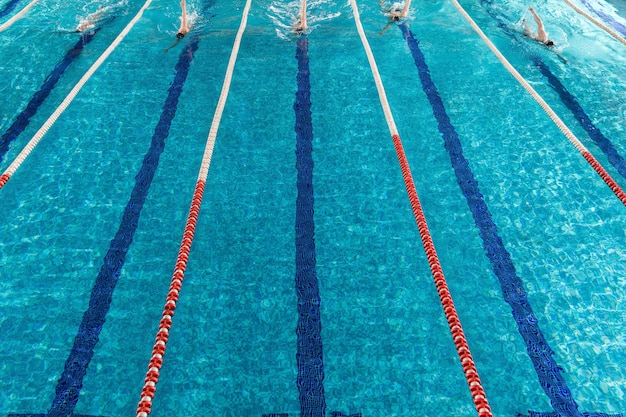 Kostenloses Foto fünf männliche schwimmer rennen gegeneinander