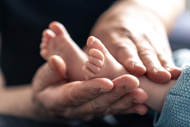 Kostenloses Foto füße eines neugeborenen in den händen einer großmutter in nahaufnahme