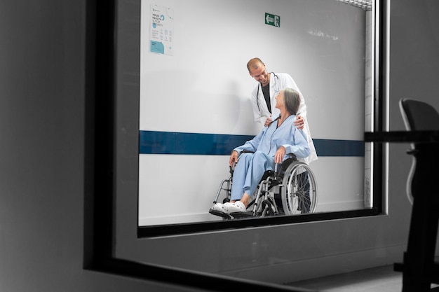 Full Shot Arzt und Patient im Rollstuhl