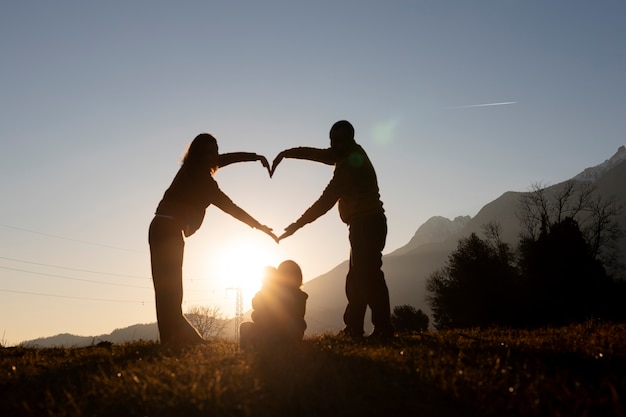 Kostenloses Foto full-shot-familiensilhouette in der natur bei sonnenuntergang