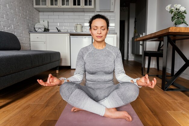 Full Shot Frau auf Yogamatte