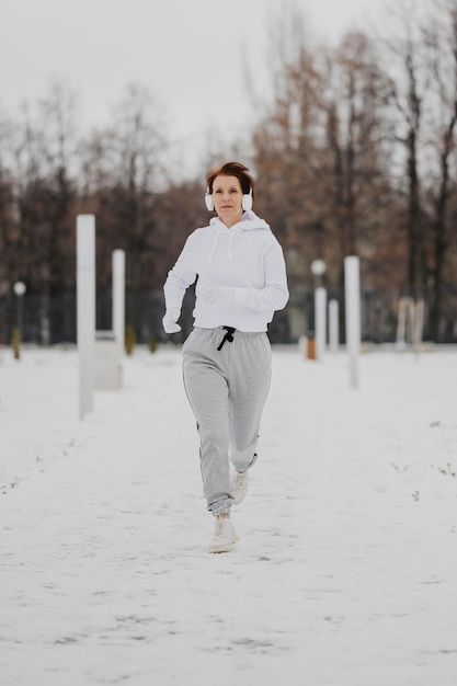 Full Shot Frau läuft im Schnee