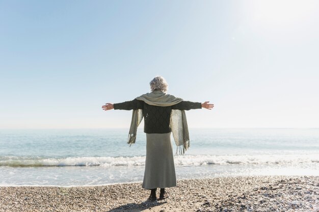 Full Shot Frau meditiert am Meer