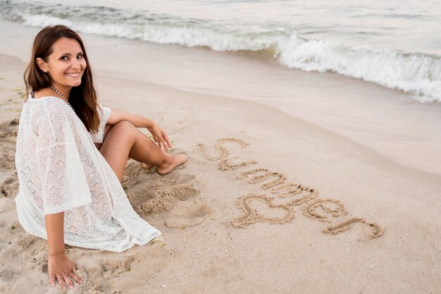 Full Shot Frau sitzt auf Sand