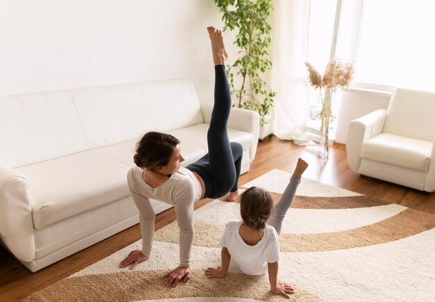 Full Shot Frau und Mädchen trainieren zu Hause