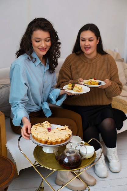 Kostenloses Foto full-shot-frauen, die leckeres essen genießen