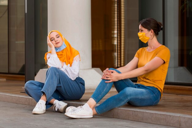 Full Shot Frauen mit Masken sitzen