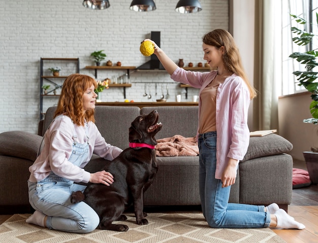 Kostenloses Foto full shot frauen und hund mit ball