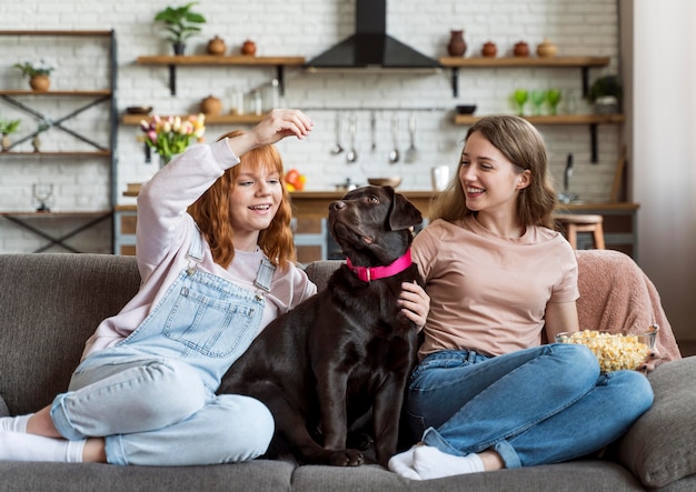 Full shot frauen und hund sitzen auf der couch