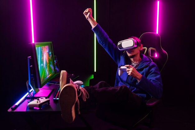 Full-Shot-Gamer, der auf einem Stuhl sitzt