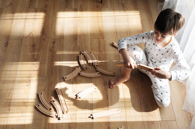 Kostenloses Foto full-shot-kind, das mit holzstücken spielt