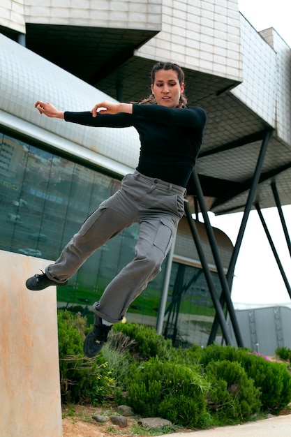 Kostenloses Foto full-shot-mädchen, das parkour macht