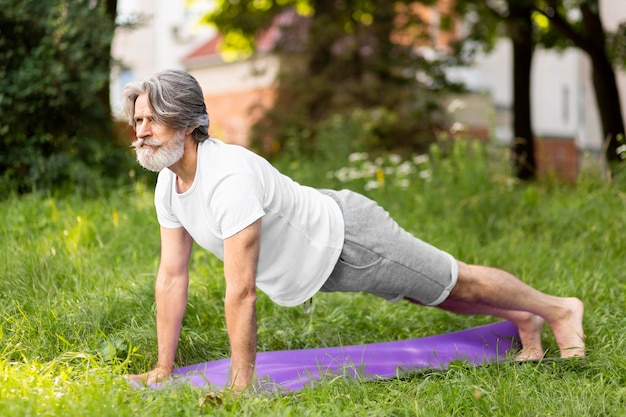 Full Shot Mann praktiziert Yoga