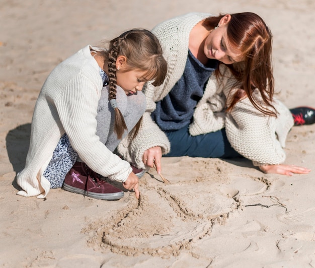 Full Shot Mutter und Mädchen spielen am Strand