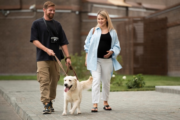 Full-Shot-Paar, das mit Hund spazieren geht