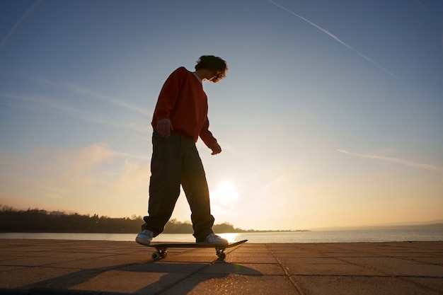 Kostenloses Foto full-shot-skater posiert bei sonnenuntergang