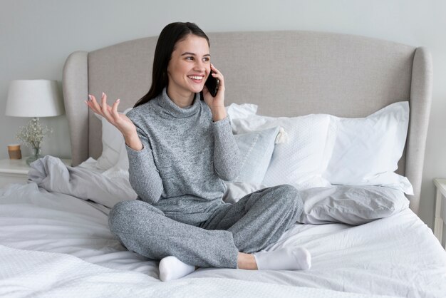 Full-Shot-Smiley-Frau am Telefon sprechen