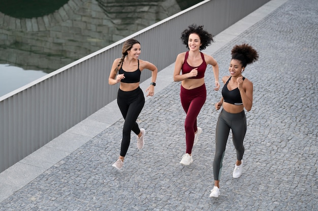 Kostenloses Foto full-shot-smiley-frauen, die zusammen laufen