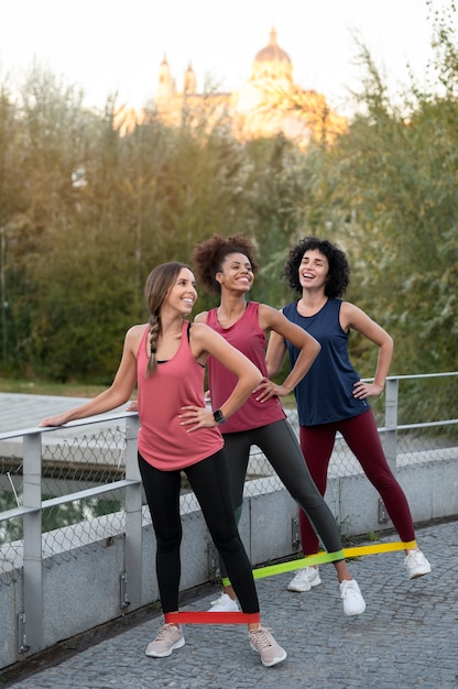 Full-Shot-Smiley-Frauen trainieren mit Bands