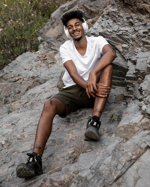 Full Shot Smiley Mann sitzt auf Felsen