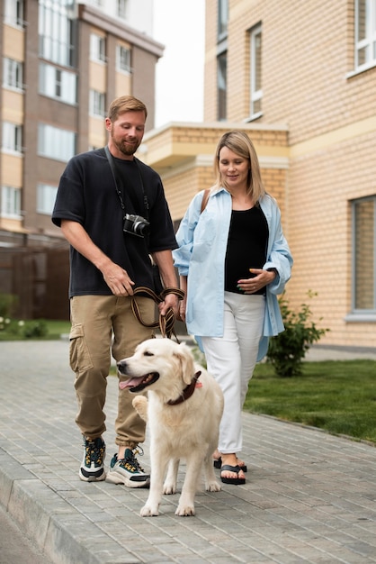 Full-Shot-Smiley-Paar, das mit Hund spazieren geht