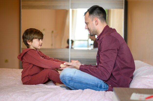 Full Shot Sohn und Vater Händchen haltend