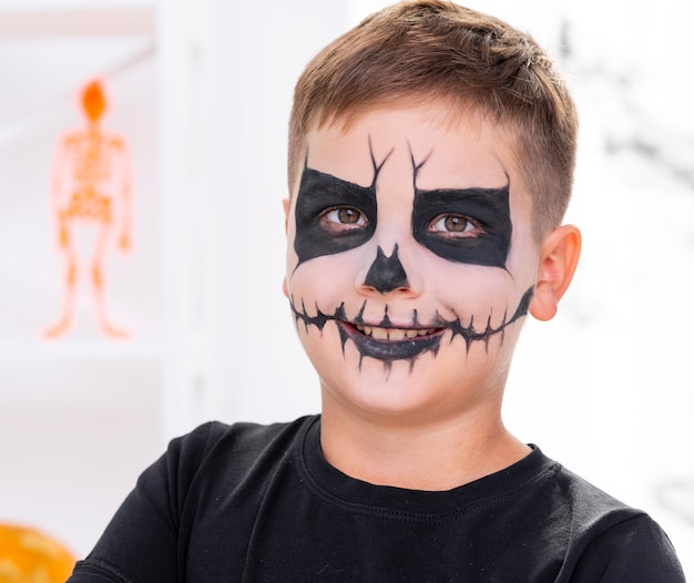 Furchtsamer Junge mit dem Gesicht gemalt für Halloween