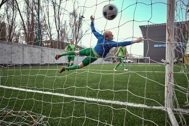 Kostenloses Foto fußball-fußballtorhüter macht tauchen sparen