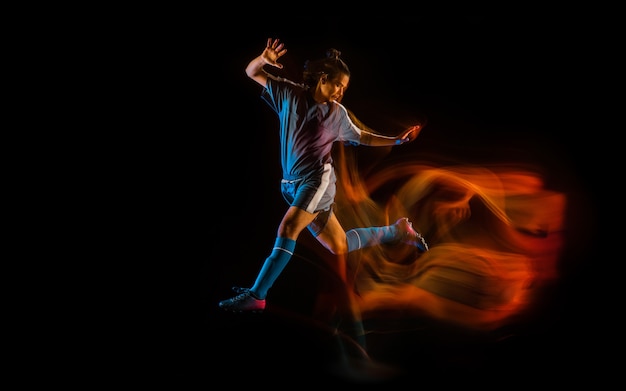 Fußball- oder Fußballspieler auf schwarzem Hintergrund in gemischten Lichtfeuerschatten