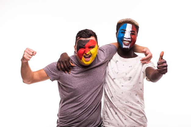 Fußballfansanhänger mit gemaltem Gesicht der Nationalmannschaften von Frankreich und von Deutschland lokalisiert auf weißem Hintergrund
