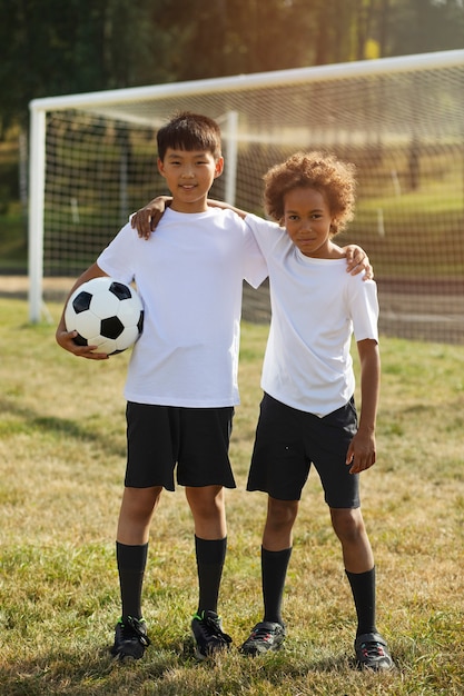 Fußballspielende Kinder unter Aufsicht eines Fußballtrainers