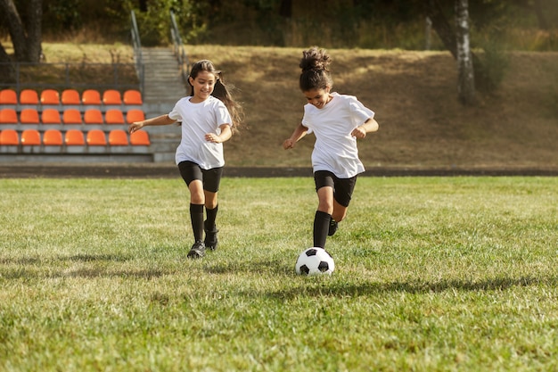 Fußballspielende Kinder unter Aufsicht eines Fußballtrainers