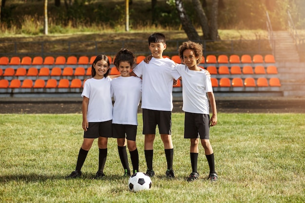 Kostenloses Foto fußballspielende kinder unter aufsicht eines fußballtrainers