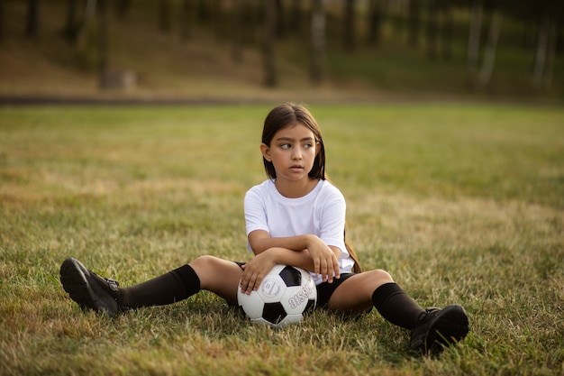 Fußballspielende Kinder unter Aufsicht eines Fußballtrainers