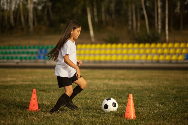 Fußballspielende Kinder unter Aufsicht eines Fußballtrainers